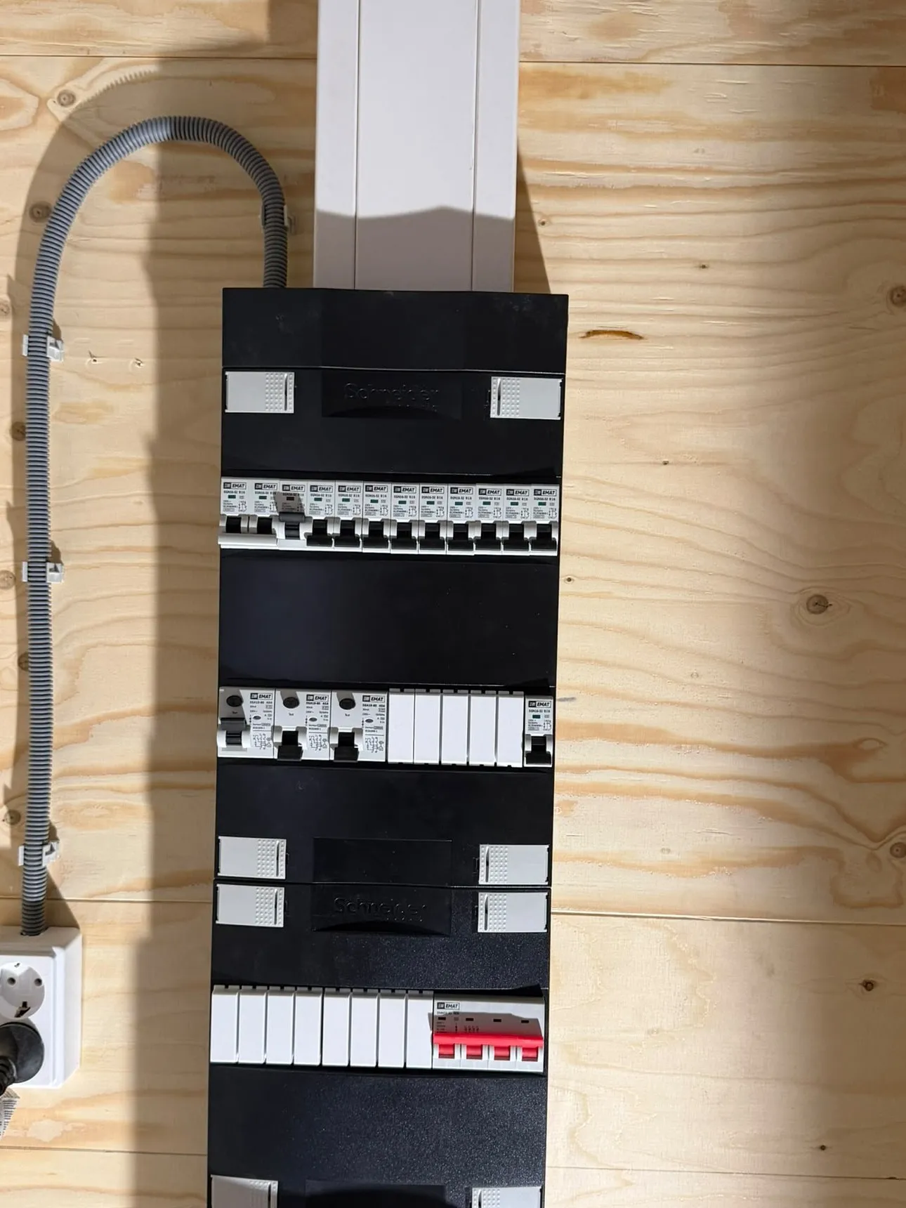 Nieuwe groepenkast met automaten en aardlekschakelaars op een houten achterwand